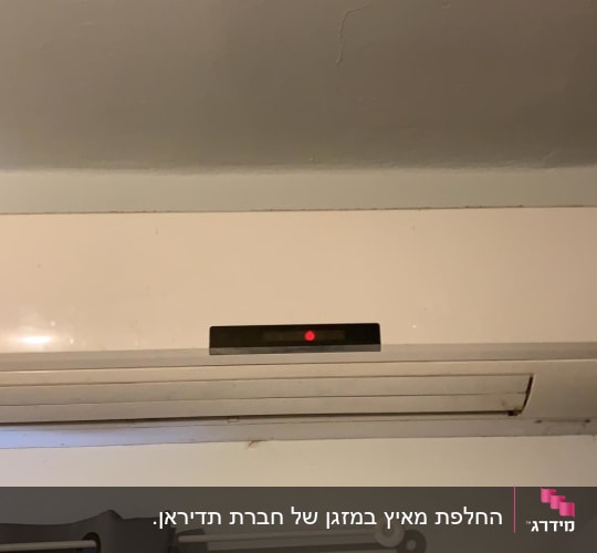 מזגן קיר לבן עם תצוגה דיגיטלית אדומה